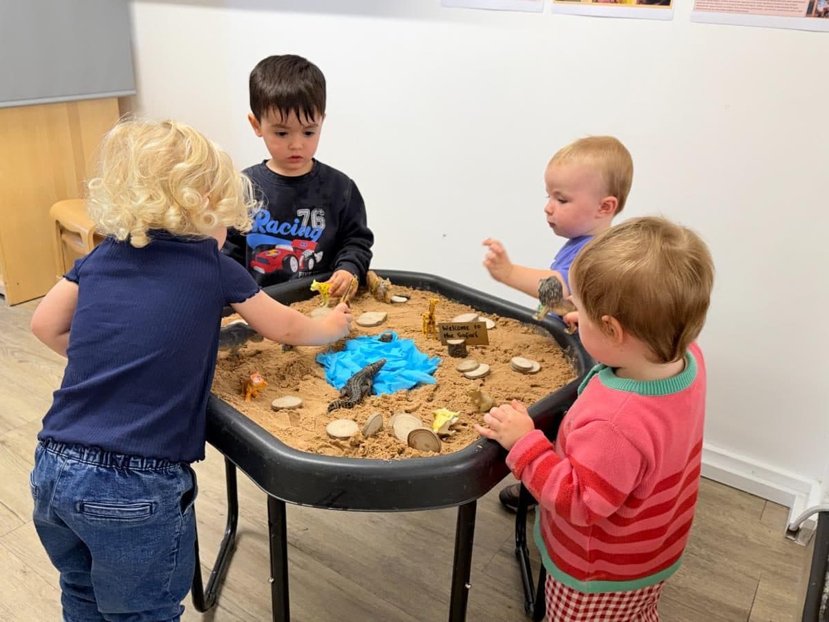 Unique child montessori children exploring sensory sand table play