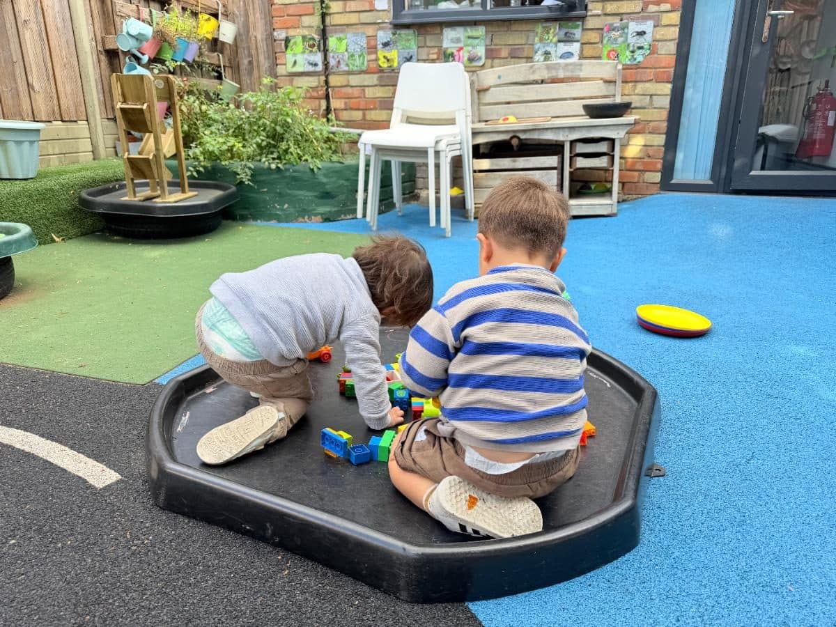 Children playing together in a tyre sandbox at Higham Hill