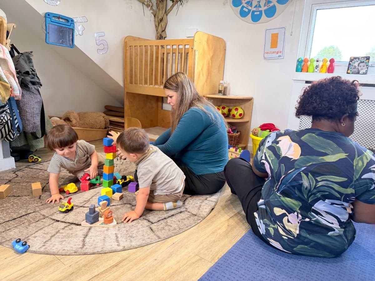 Unique child montessori practitioners playing blocks with children